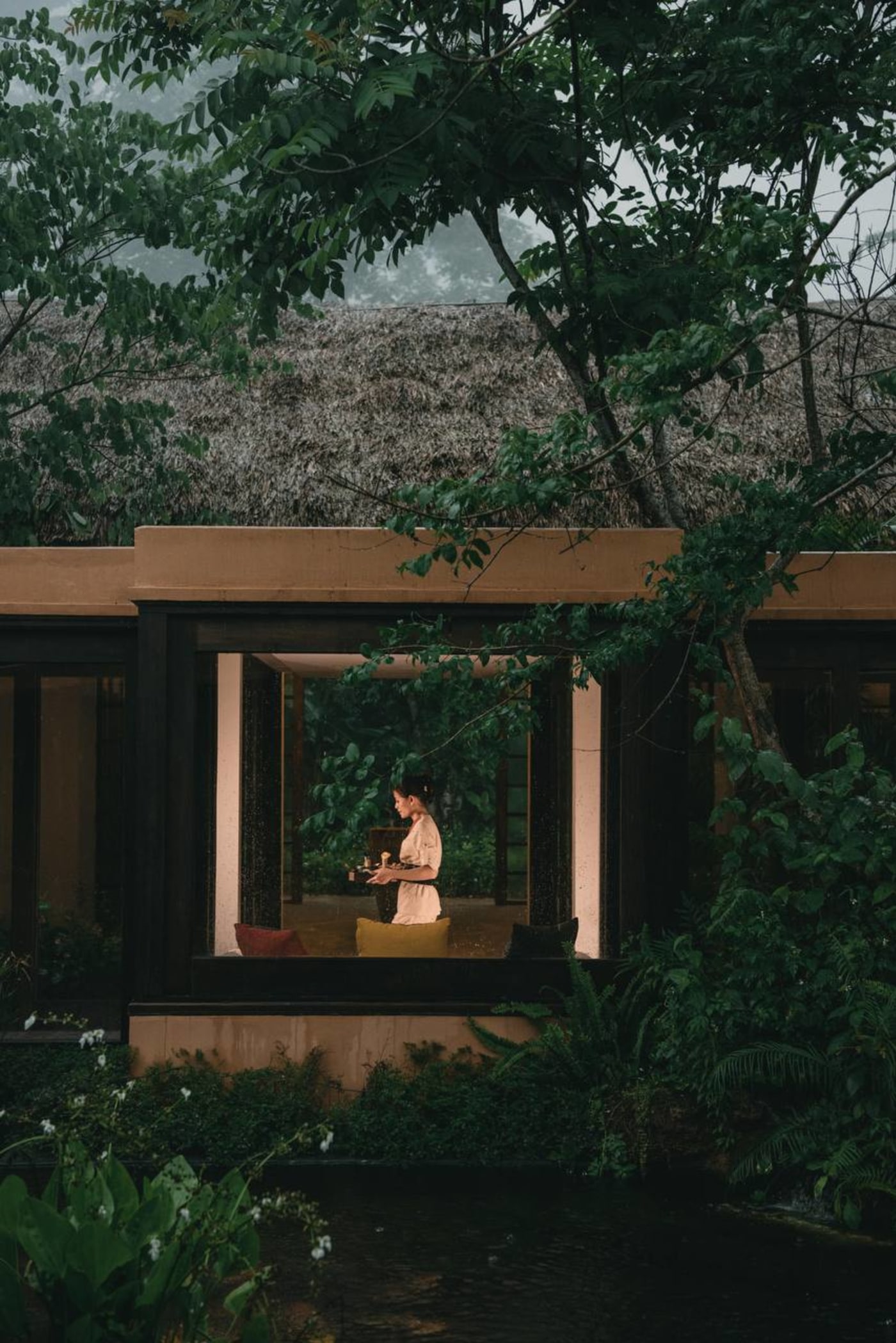 Spa interior with glass walls overlooking garden and reflecting pool at Avana Retreat