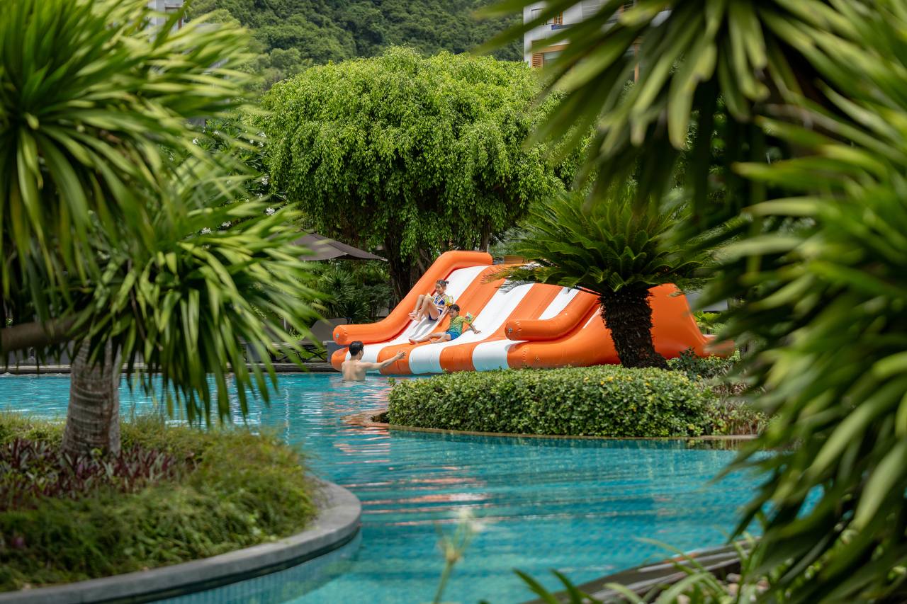 Family fun on the inflatable waterslide in the resort pool