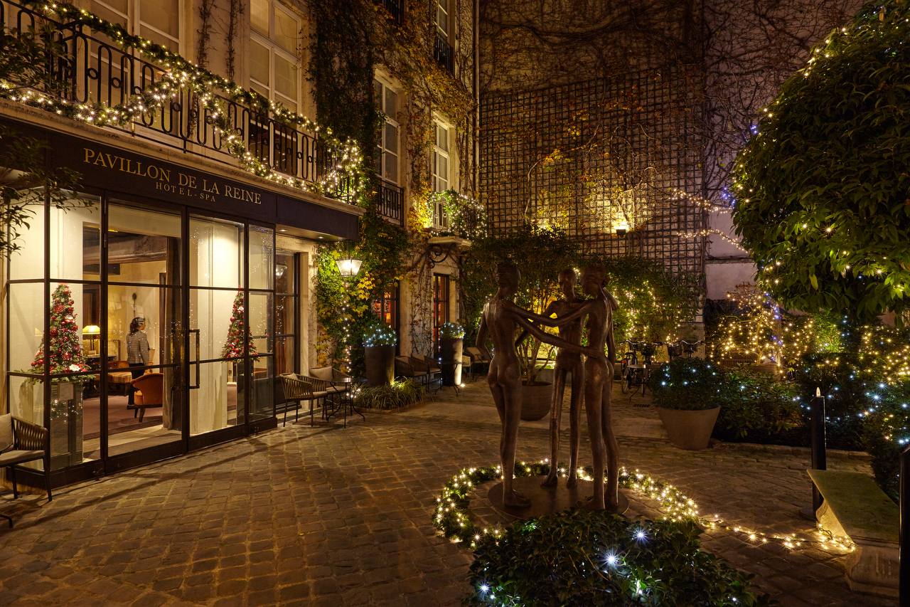 Courtyard garden illuminated at evening at Pavillon de la Reine