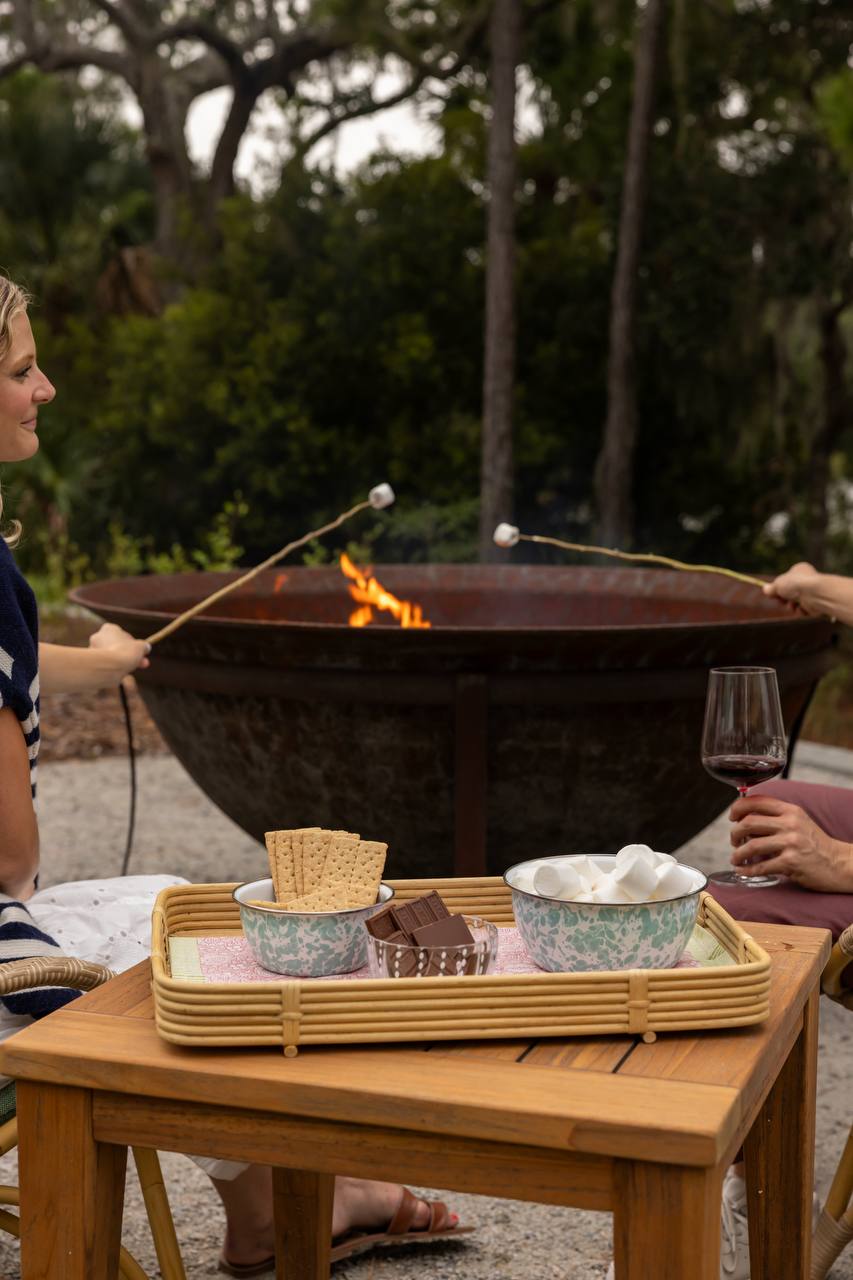 Guests roasting marshmallows around the fire pit at The Dunlin, Auberge Collection