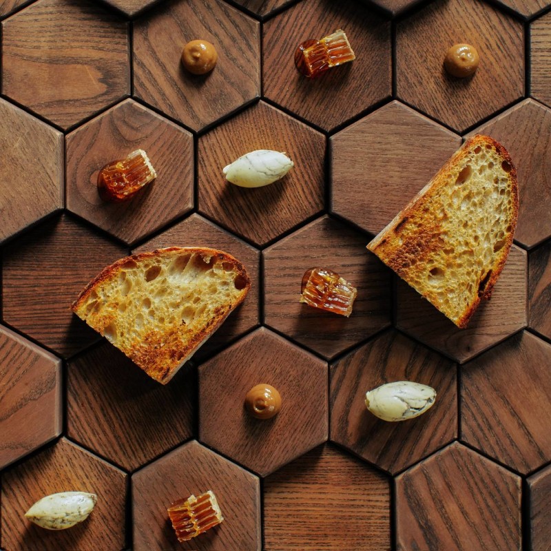 Nephele signature sourdough with honeycomb, truffle butter, and breadso on hexagonal board representing beehive