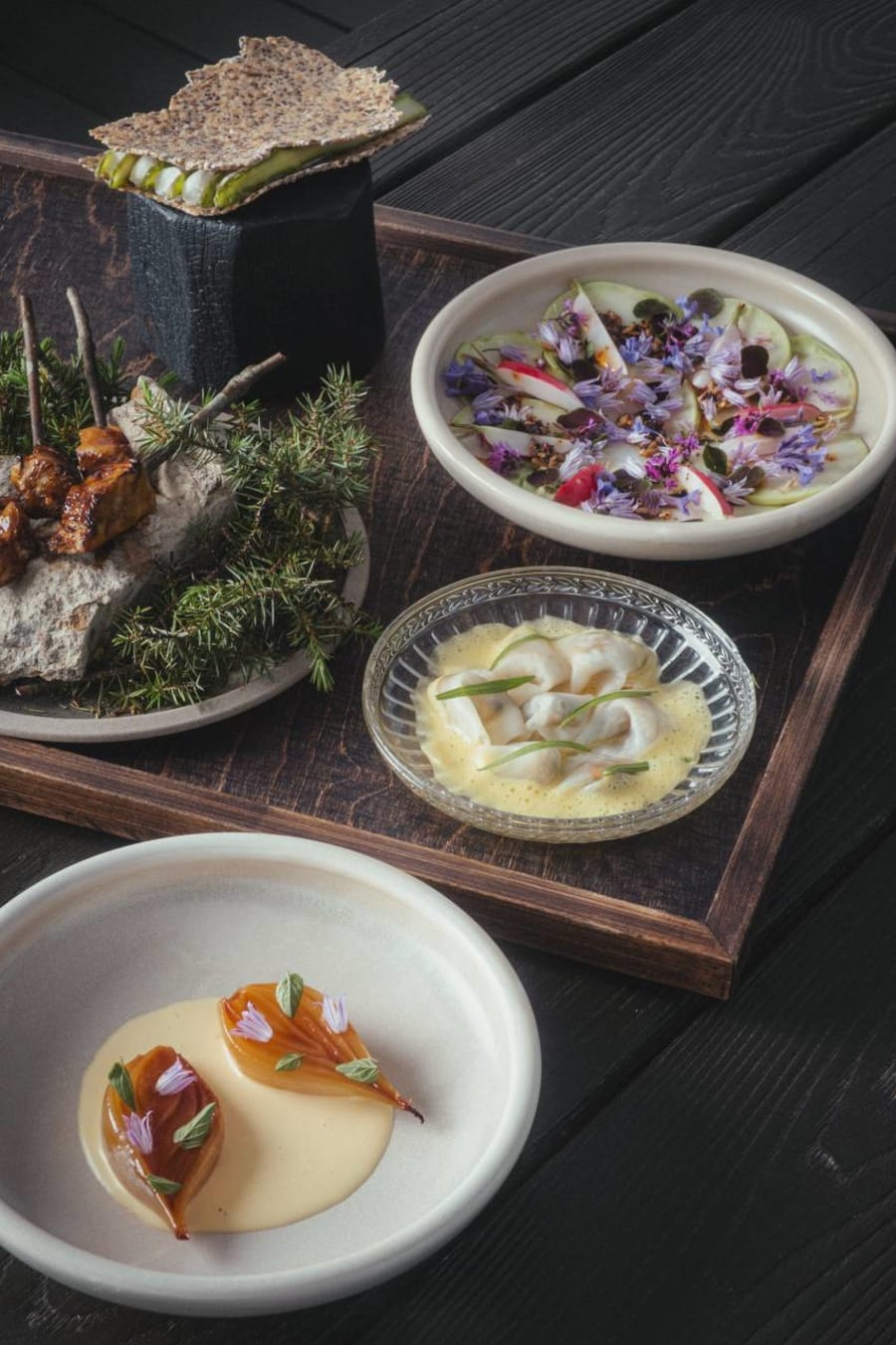Nordic tasting menu with seasonal foraged ingredients on dark wood