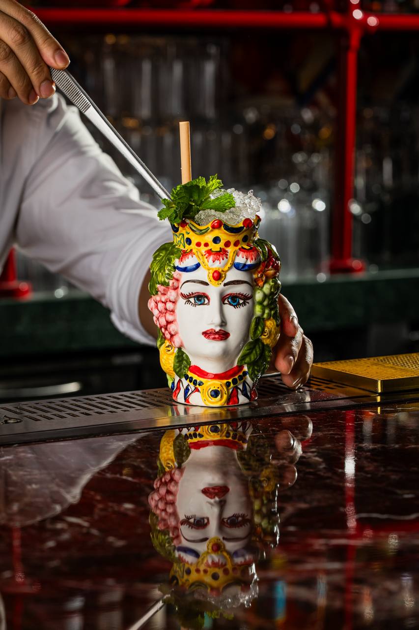 Cocktail served in hand-painted ceramic head vessel at Felicità Dubai
