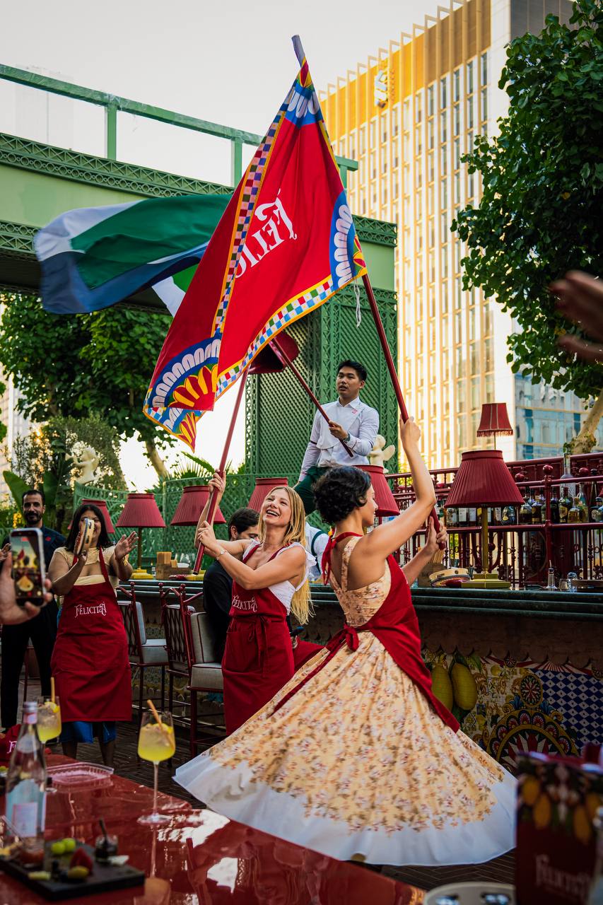 Performers with ceremonial flags at Felicità rooftop with Burj Khalifa views
