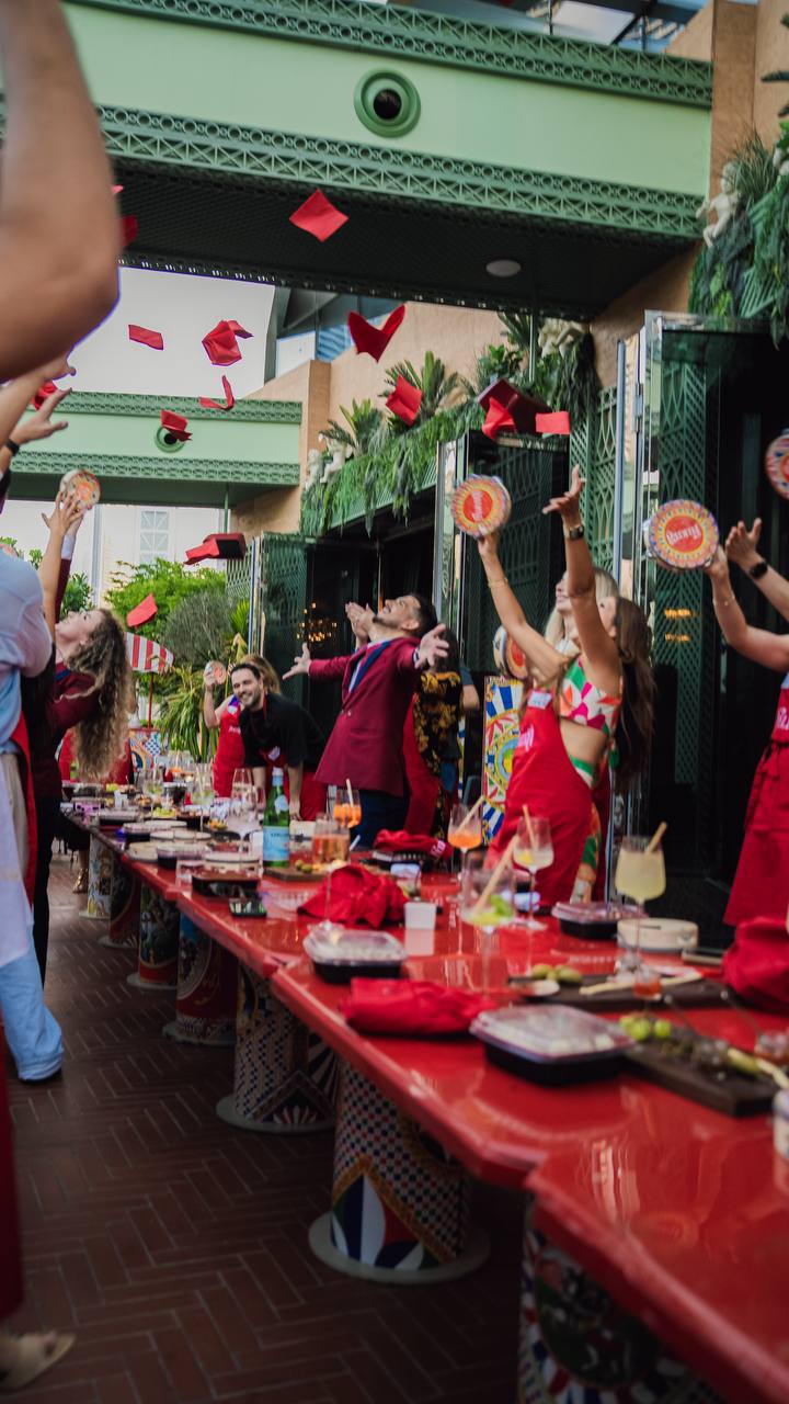 Guests toss red napkins skyward during a vibrant brunch celebration at Felicità