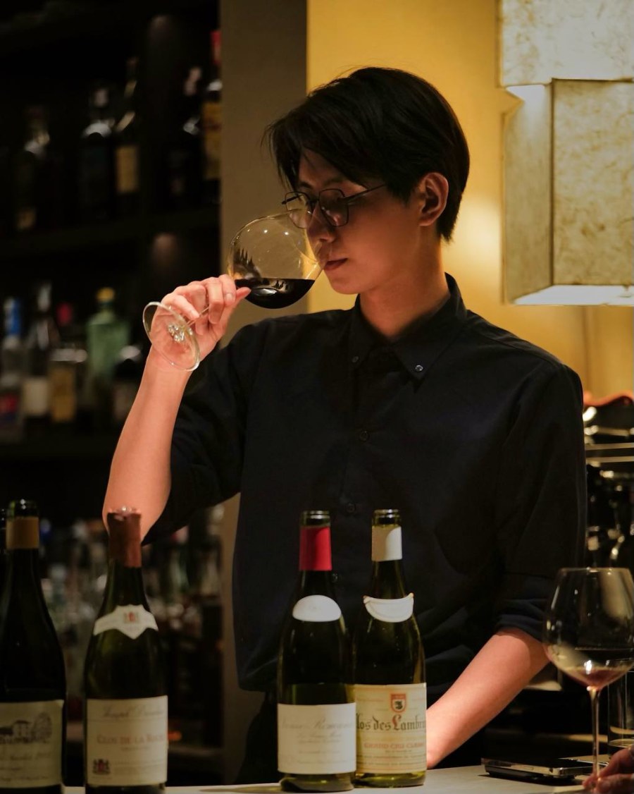 Hoai Van, Junior Sommelier at Nephele, nosing a glass of red wine during tasting