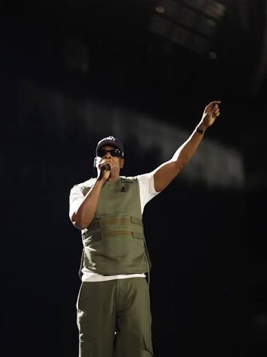 Jay-Z performing solo on stage at Tottenham Hotspur Stadium, pointing upward during the JAY-Z 30 Tour