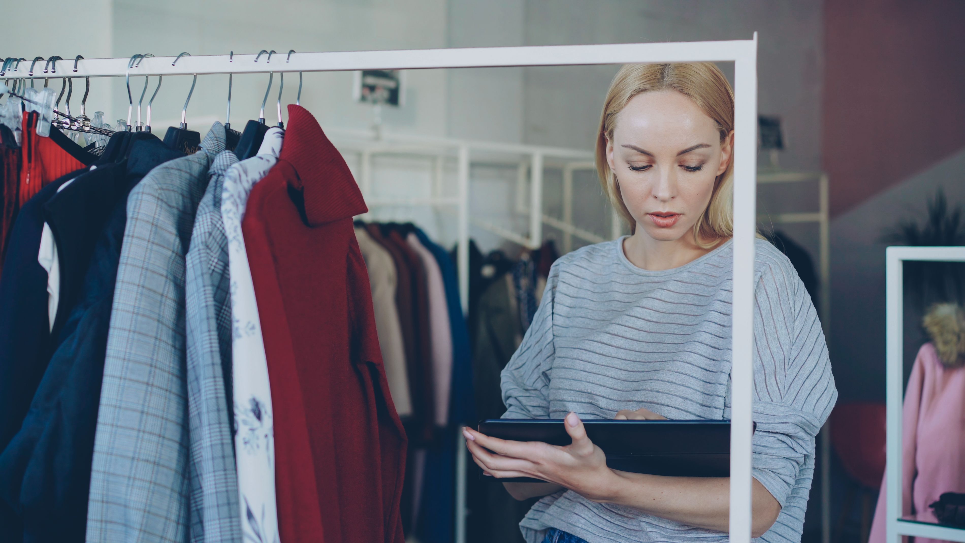 Nhân viên shop thời trang sử dụng máy tính bảng quản lý bán hàng