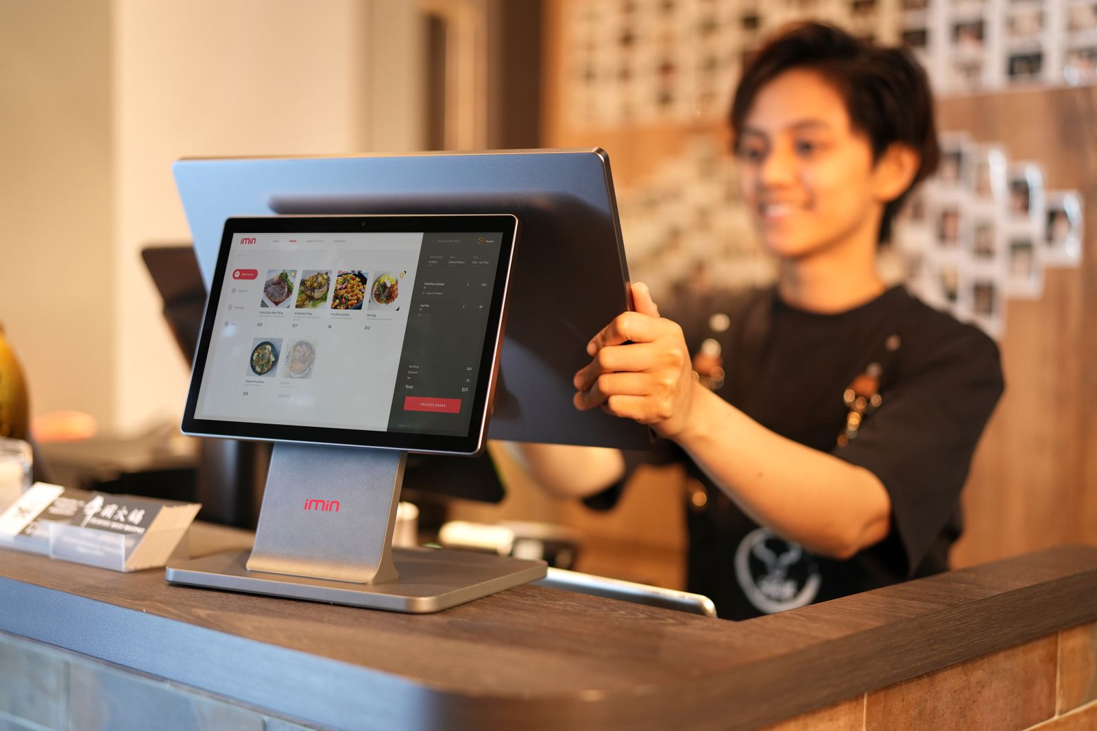 Nhân viên bán hàng thời trang sử dụng tablet POS tại quầy thu ngân
