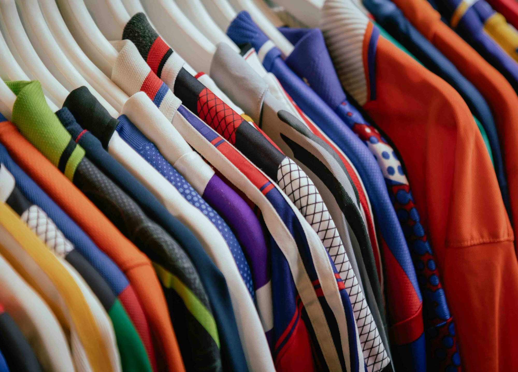 Giá treo quần áo nhiều màu sắc trong shop thời trang, minh họa quản lý tồn kho theo size và màu