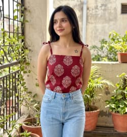 Young Indian Woman in Printed Maroon Camisole Standing on Balcony