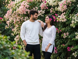 Candid Young Indian Couple Standing Near Flowering Bougainvillea Garden Wall