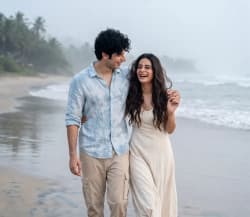 South Asian Couple Walking Along Misty Tropical Beach in Candid Portrait