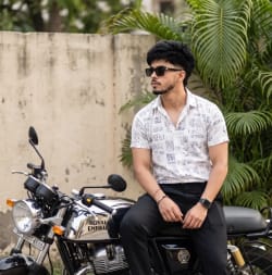 Stylish Man Sitting on Chrome Royal Enfield Motorcycle in Urban Setting