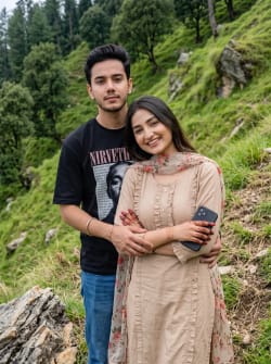 Realistic Outdoor Portrait of Romantic Young Couple on Green Hillside