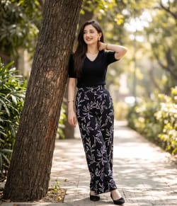 Woman in Printed Palazzo Pants Leaning Against Tree in Park
