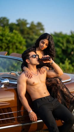 Romantic High Fashion Editorial Couple Resting on Vintage Convertible Car Outdoors