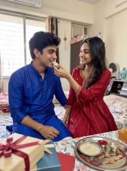 Candid Indian Siblings Celebrating Raksha Bandhan in Bedroom Setting