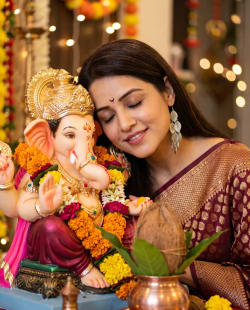 Indian Woman Devotionally Posing With Ganesha Idol During Ganesh Chaturthi
