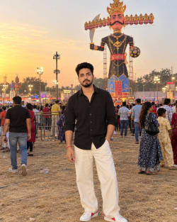 Young Man in Black Shirt Standing Before Ravana Effigy at Dusk Fair