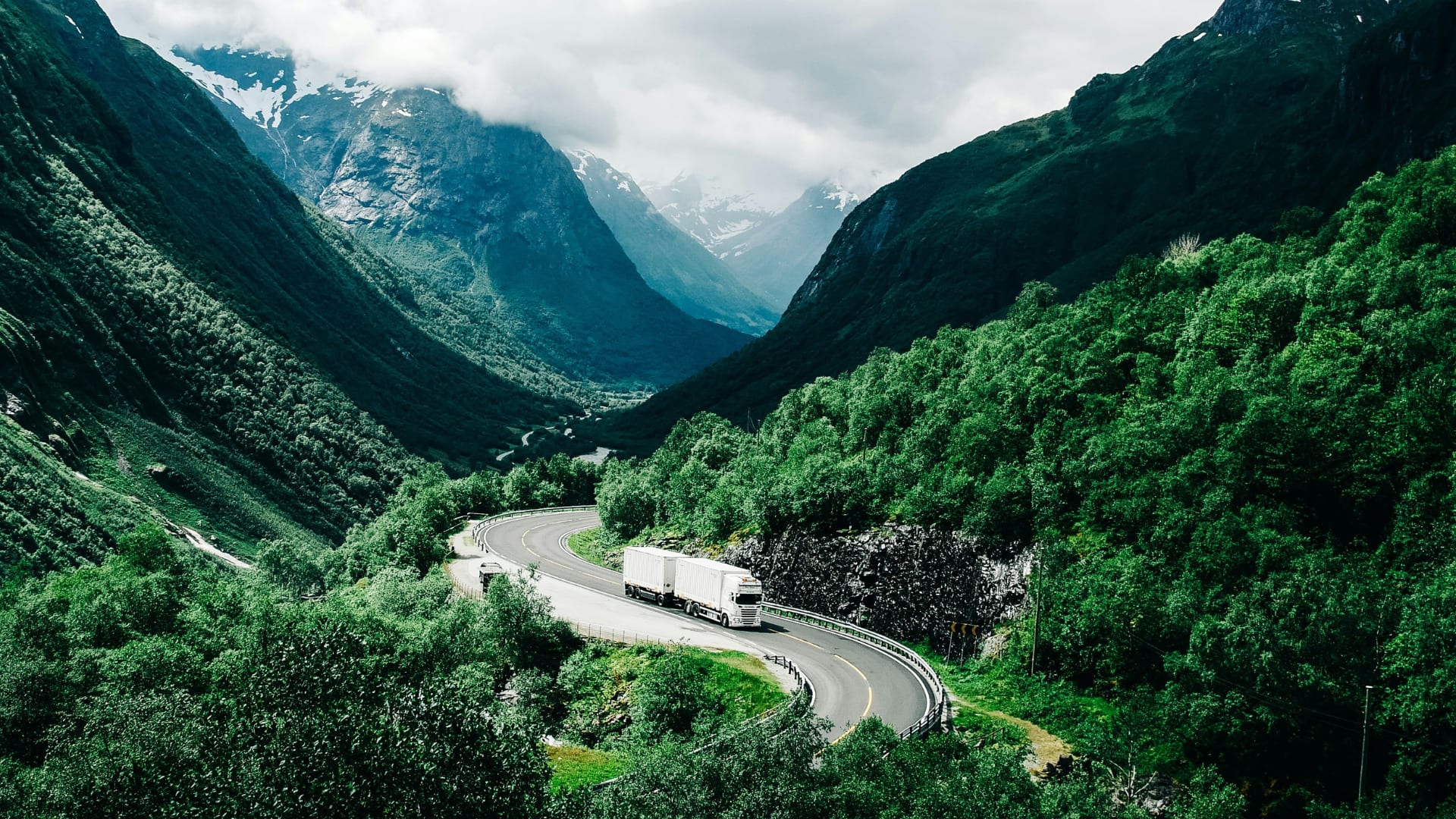 Truck driving through wooded mountains.