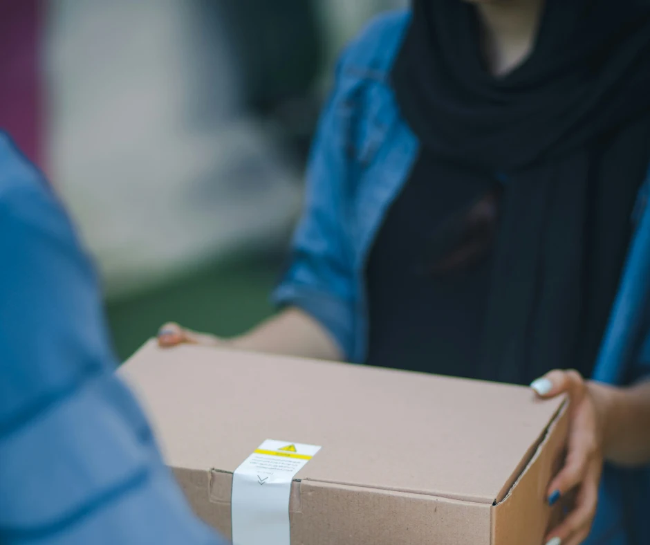 woman holding box recieving from man