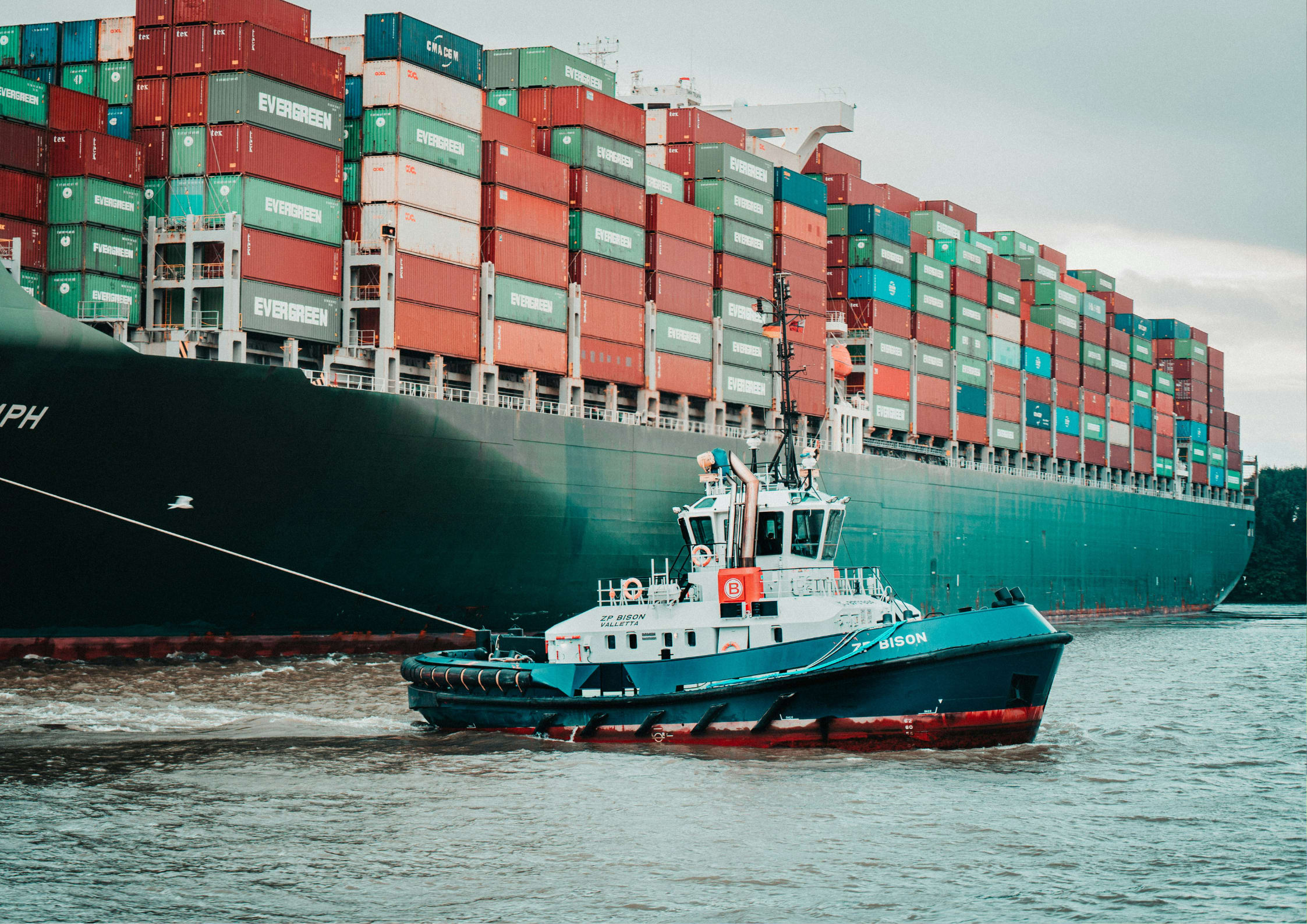 tugboat pulling large ship for shipping containers
