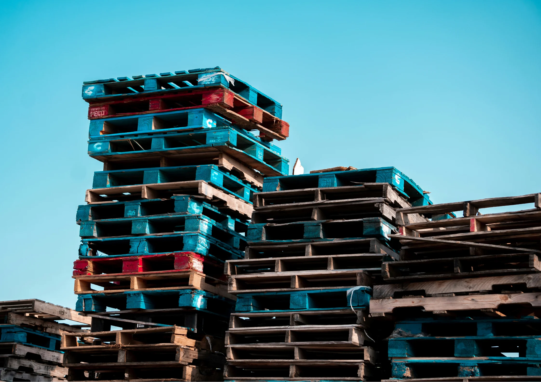 stacked up pallets talking about freight cost reduction through recycled pallets