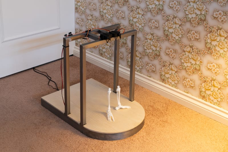 a metal structure holding two small skeleton legs