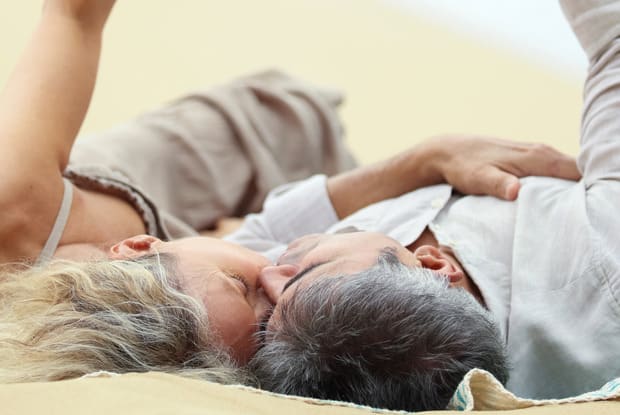 a couple laying on a beach