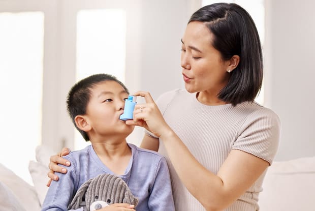 a mother administering an asthma inhaler for her child