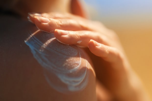 a woman applying medication to the shoulder