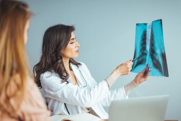 a doctor showing a patient their lung x-ray