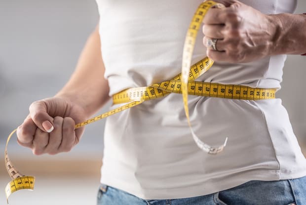 a man with a measuring tape around his waist