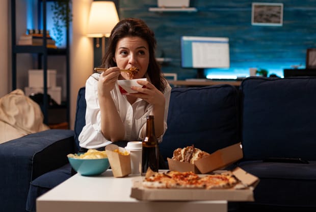 a woman enjoying food on a couch