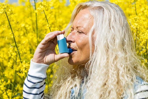 a woman taking a puff from her inhaler