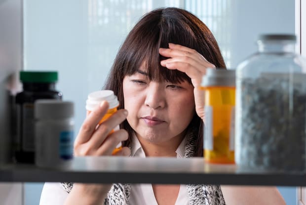 a woman looking into her medicine cabinet