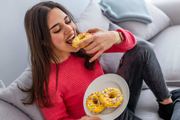 a person eating sugary snacks on the couch