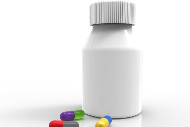 a white pill bottle next to colored pills