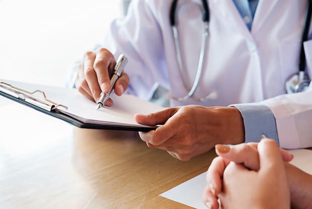 a doctor showing their patient their prescription