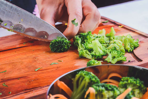 person chopping up broccoli