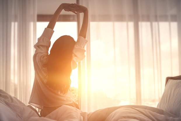 a woman stretching in bed 