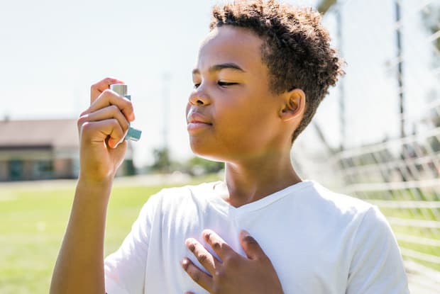 a child using an asthma inhaler