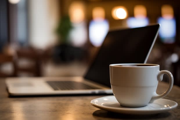 a cup of coffee in front of a laptop