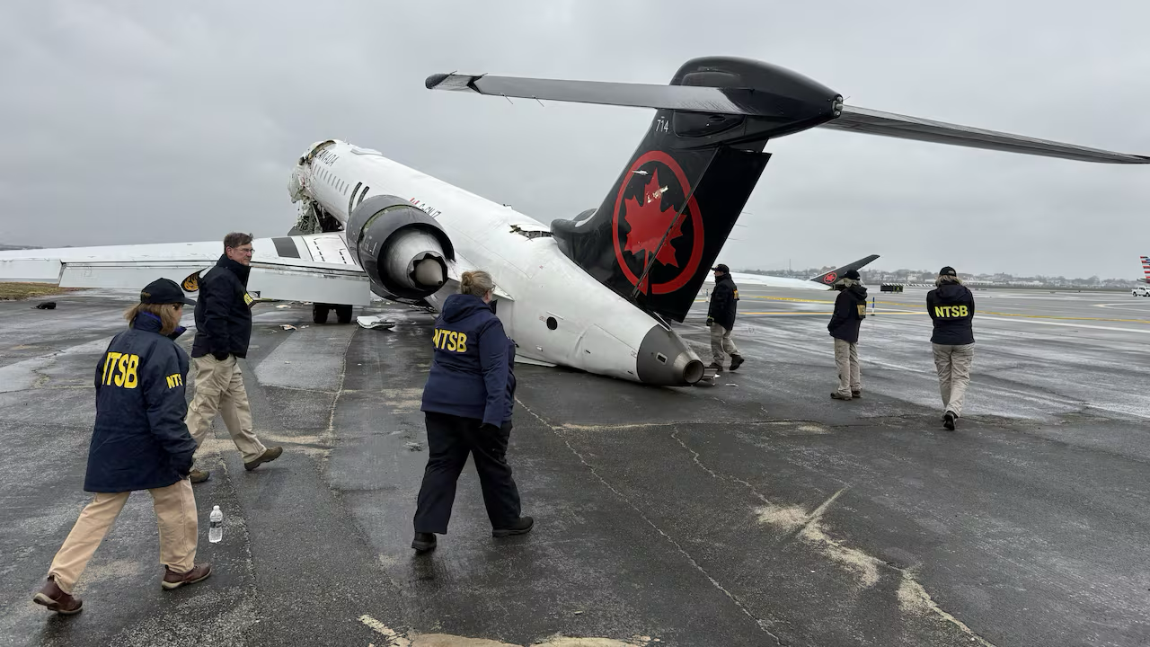 NTSB Investigator conducting on-scene examination of Air Canada CRJ-900 wreckage on Runway 04 at LaGuardia Airport (KLGA)