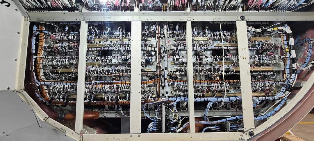 Internal view of the Airbus A320 avionics bay showing densely packed electronic systems, wiring, and cooling pathways