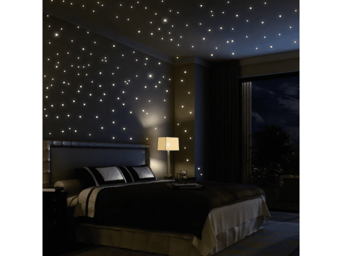 Tiny lights on the ceiling create a stunning starlight effect in this bedroom.