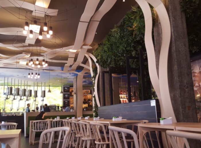Interior of a café with curved wood panels creating an interesting ceiling feature.