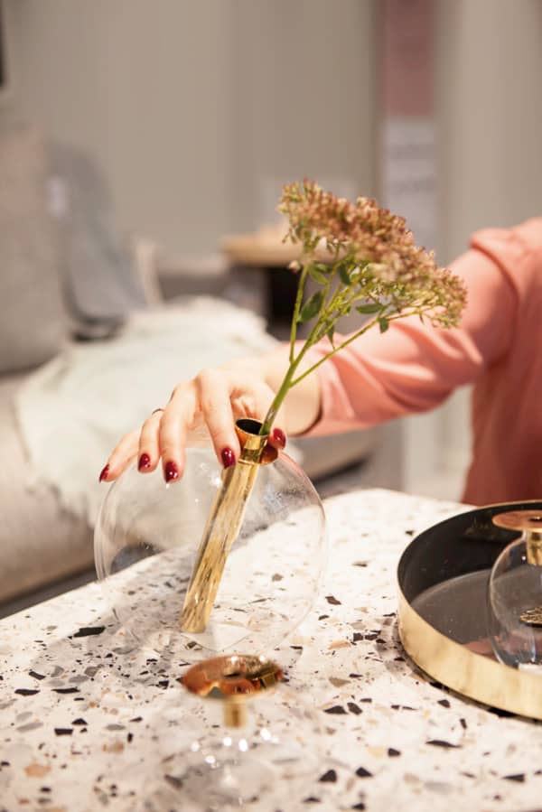 Me admiring a gold minimalist vase at Bolia.