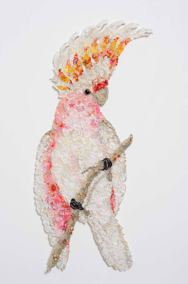 Textile art parrot made up of reused pieces of needlework, pins and tulle.